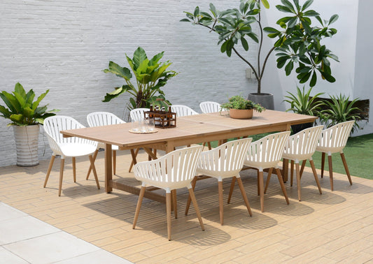 Rectangular outdoor dining table with 10 white armchairs in a garden setting.