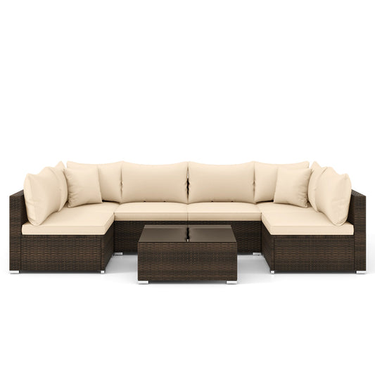 Studio view of the seven-piece beige PE rattan outdoor sectional set with coffee table.