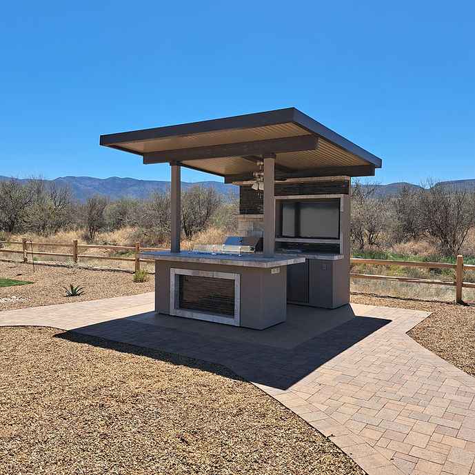 Angled view of the covered outdoor kitchen island with a built-in gas grill.