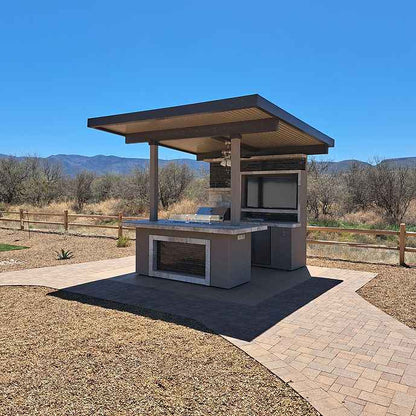 Angled view of the covered outdoor kitchen island with a built-in gas grill.