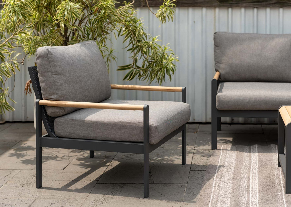 Outdoor lounge chair with grey cushions arranged in a patio setting.