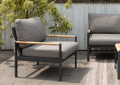 Outdoor lounge chair with grey cushions arranged in a patio setting.
