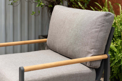 Close view of an outdoor sofa back with gray upholstery and mesh support.
