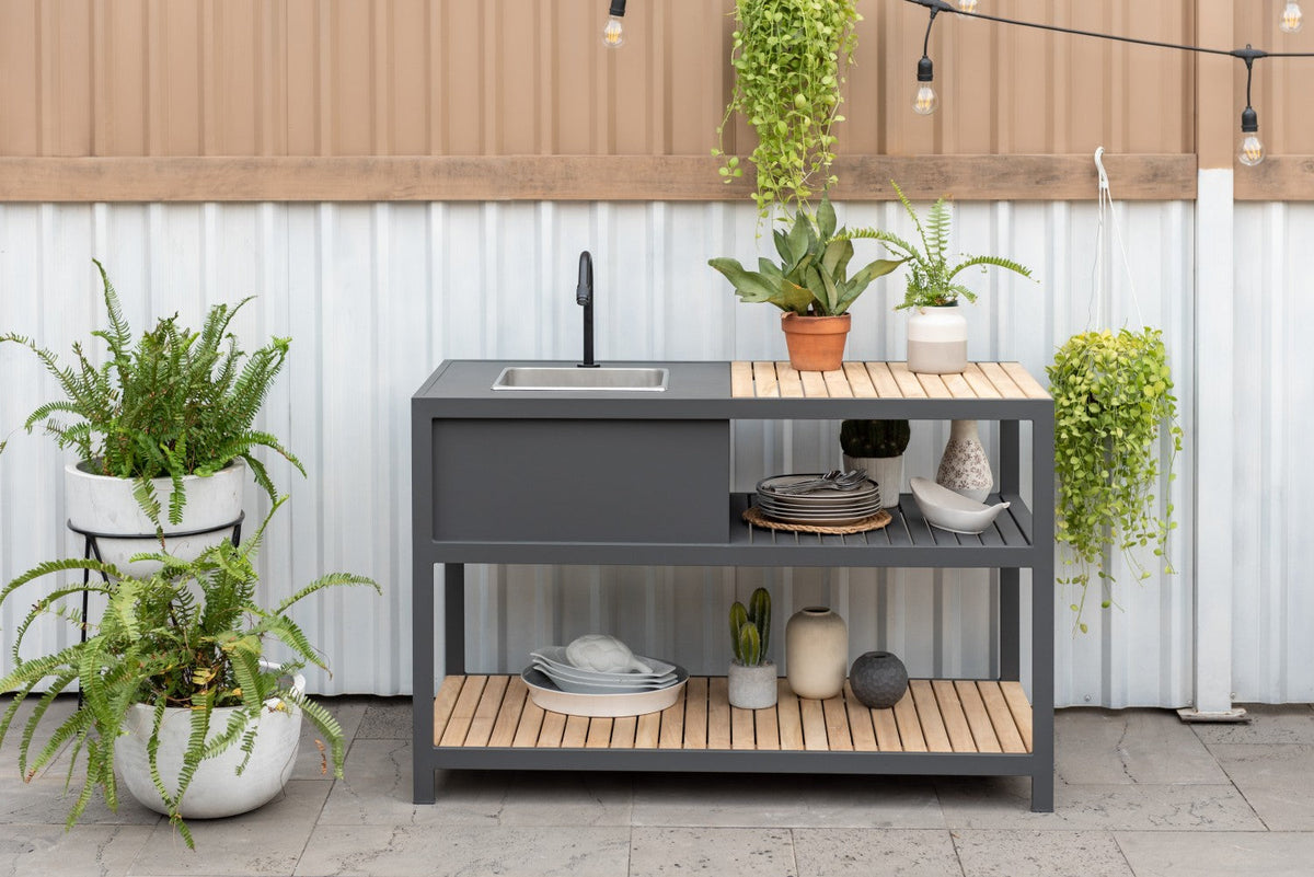 Outdoor kitchen unit with a wood-tone work surface and lower shelf.
