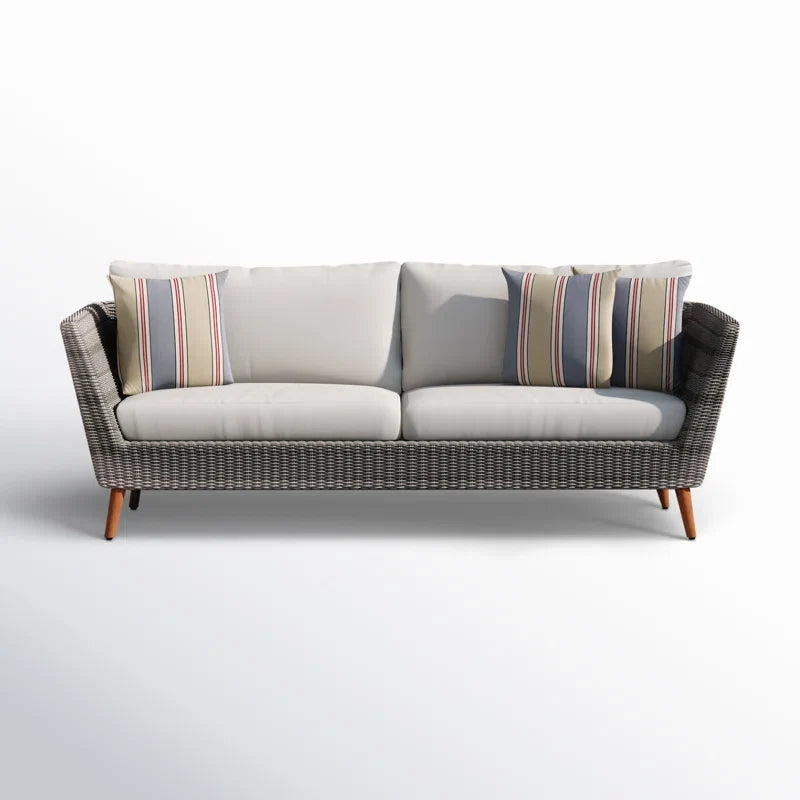 Wicker outdoor sofa with cushions on a white background.
