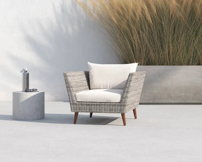 Wicker outdoor armchair with cushion in an outdoor setting.