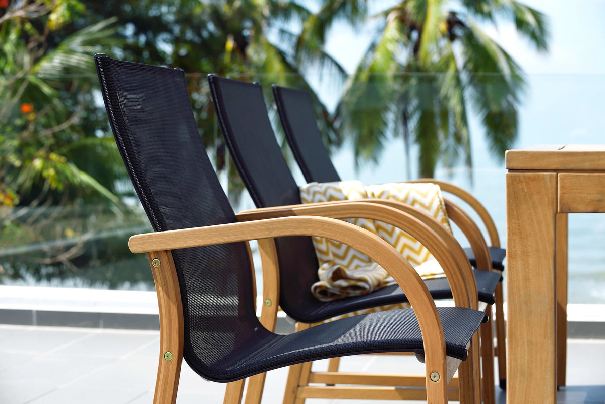 Row of black armchairs with curved armrests beside a teak dining table.