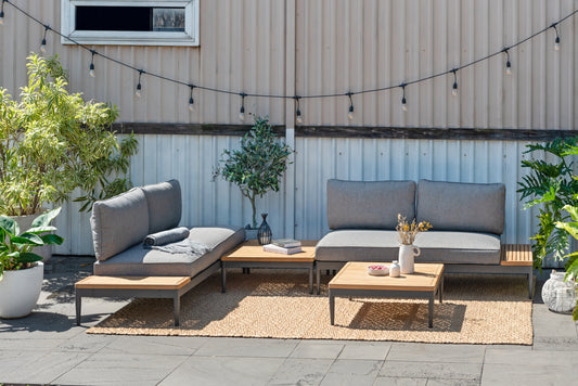 Topaz outdoor seating arrangement with gray cushions, dark aluminum frames, a square coffee table, and wood-tone side surfaces.