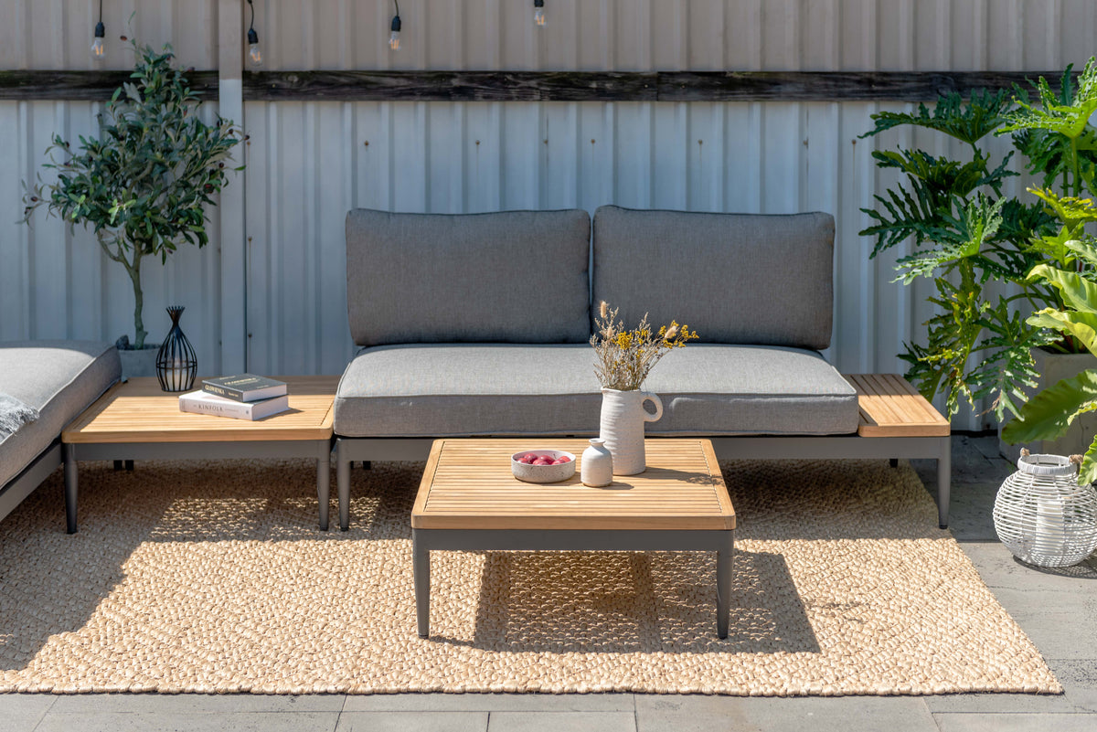 Gray two-seater outdoor sofa with wood-tone side surfaces and a square coffee table.