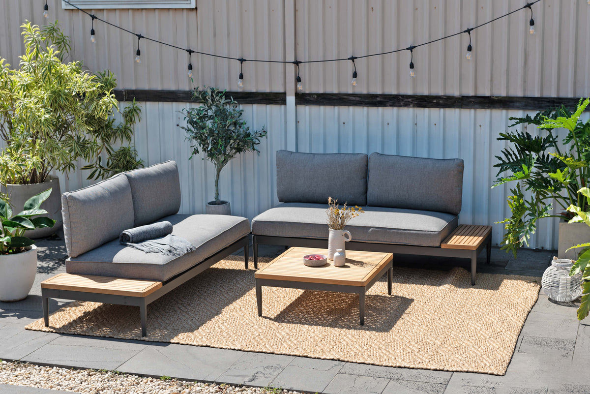 Topaz three-piece outdoor seating set with gray cushions, dark gray aluminum frames, and a coffee table on a patio.