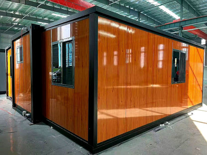 A modular office container with a glossy orange-brown wood grain finish and black metal framing, shown inside a warehouse.