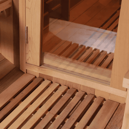 Close-up of red cedar sauna bench slats and the glass door threshold.