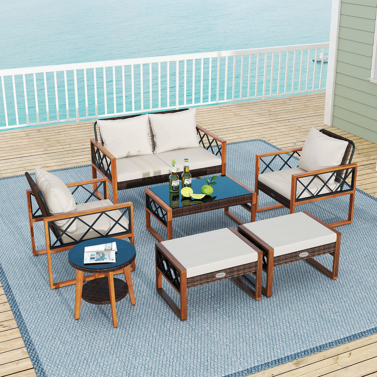 Outdoor conversation set with white cushions on a deck overlooking the water.
